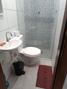 a bathroom with a shower and a toilet and a sink at Suítes Monte Cristo II in Aparecida