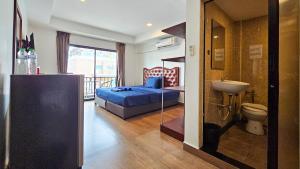 a bedroom with a bed and a bathroom with a sink at Smyrna in Pattaya