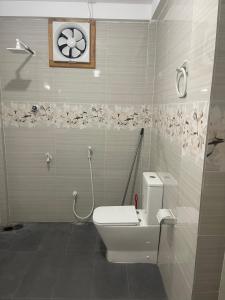 a bathroom with a toilet and a clock on the wall at The Yarl Home in Jaffna +10 photos