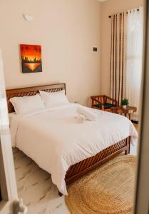a bedroom with a large white bed and a table at Mnazinisky B&B in Zanzibar City