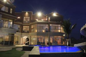 a large house with a swimming pool at night at فلل كوڤا بيتش - للعائلات فقط in Durat Alarous