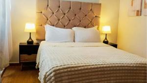 ein Schlafzimmer mit einem großen Bett und zwei Lampen in der Unterkunft Casa Luma in Aguascalientes