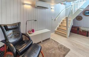 a living room with a chair and a desk and stairs at Nice Home In Ask With Wifi in Ask i Nordhordaland +16 photos