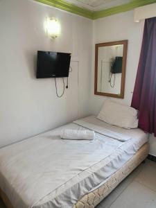 a bedroom with a bed and a tv on the wall at Hotel Wings Kuala Lumpur in Kuala Lumpur
