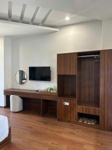 a bedroom with a large wooden entertainment center with a television at Hotel ĐÁ ĐỎ in Danang