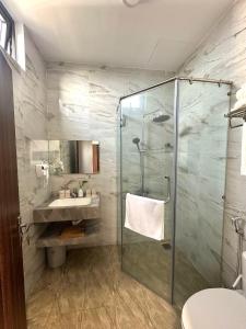 a bathroom with a glass shower and a sink at Hotel ĐÁ ĐỎ in Danang +36 photos