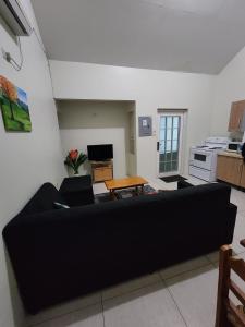 a living room with a black couch and a table at Crown Point Condos by Nasin in Crown Point