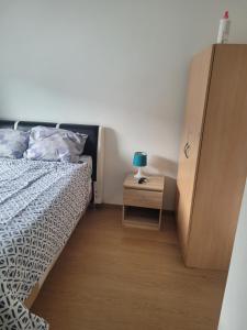 a bedroom with a bed and a night stand with a lamp at Repos chez l habitant in Rennes
