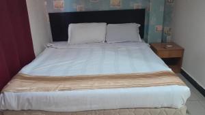 a bedroom with a large bed with two pillows at Hotel Wings Kuala Lumpur in Kuala Lumpur