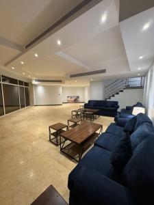 a large living room with blue couches and a table at فلل كوڤا بيتش - للعائلات فقط in Durat Alarous