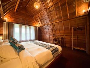 a bedroom with a bed in a wooden room at Casa Vella Cottages by AGATA in Bedugul