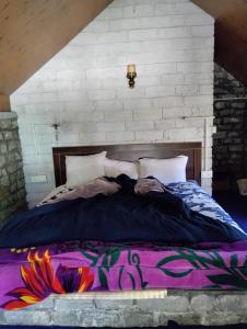 a bedroom with a large bed with a colorful blanket at Ambika Campaign Huts in Manāli