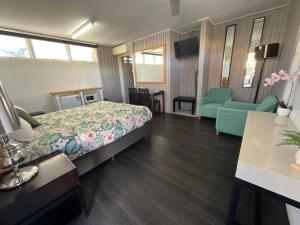 a hotel room with a bed and a chair at Dalby Parkview Motel in Dalby