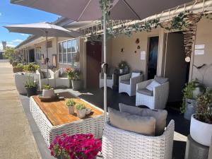 a patio with chairs and tables and umbrellas at Dalby Parkview Motel in Dalby
