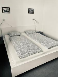 a white bed in a room with two pillows at Dorka vendégház in Kehidakustány