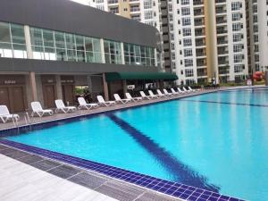 a large swimming pool with chairs and a building at Residences at Daya near Mount Austin by SR Home in Johor Bahru