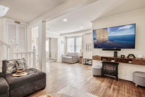 a living room with a couch and a tv on a wall at Sunshine House in Ventnor City