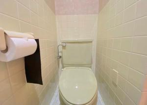 ein Badezimmer mit Toilette und einer Rolle Toilettenpapier in der Unterkunft ホテルスズカ in Matsudo