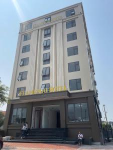 a building with people sitting in front of it at Flamengo hotel in Dong Hoi