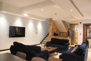 a living room with couches and a flat screen tv at فلل كوڤا بيتش - للعائلات فقط in Durat Alarous