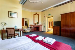 a bedroom with a bed and a desk and a television at VILLA CAPITOL in Ostróda