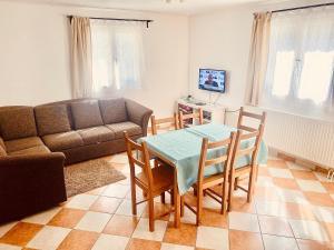a living room with a couch and a table and chairs at Levendula apartman in Kehidakustány