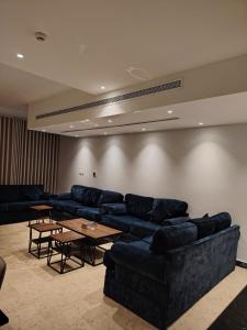 a living room with blue couches and a table at فلل كوڤا بيتش - للعائلات فقط in Durat Alarous +71 photos