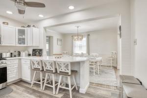 a kitchen with white cabinets and a table and chairs at Sunshine House in Ventnor City
