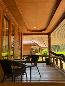 a porch with chairs and a table on a porch at Namtok Bungalows in Ko Yao Noi