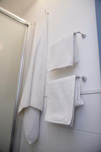baño con toallas blancas colgadas en la pared en Maison Toledo 24, en Nápoles