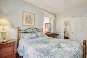 a bedroom with a bed with a blue and white comforter at Sunshine House in Ventnor City