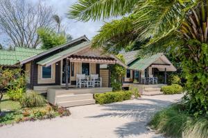 a house on the beach with a porch and chairs at Phangan Beach Resort in Ban Tai