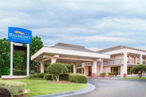 a sign in front of a building with a hotel at Baymont by Wyndham Mobile/ I-65 in Mobile