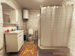 a bathroom with a shower with a sink and a toilet at Nukura in Bokonbayevo +18 photos