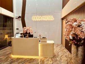 a hotel lobby with a reception desk and flowers at Cera Hotel in Ho Chi Minh City