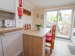 a kitchen with a counter and a table with chairs at Riverlea in Rhyl