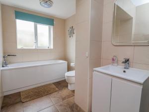 a bathroom with a tub and a toilet and a sink at Riverlea in Rhyl +33 photos