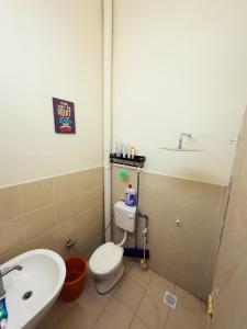 a bathroom with a toilet and a sink at Teratak Raya in Tanjung Rambutan