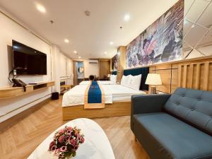 a hotel room with a bed and a couch at Cera Hotel in Ho Chi Minh City