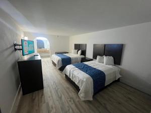 a hotel room with two beds and a window at Skylite Inn in Austin