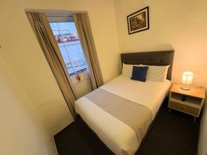a small bedroom with a bed and a window at Hotel Altara AQP in Arequipa