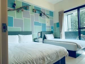 a bedroom with two beds and a blue wall at Yun He Homestay in Huwei
