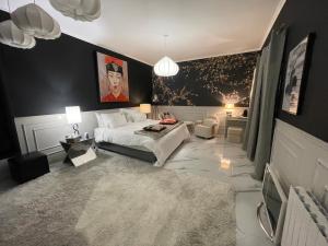 a bedroom with a white bed and a black wall at Villa Bois d'Argent in Lagraulière