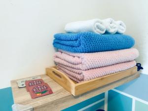 a stack of towels on a wooden shelf at Yun He Homestay in Huwei +34 photos
