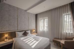 a bedroom with a bed and a chair and a window at Dan Thanh Hotel in Can Tho