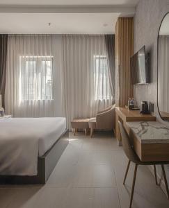 a hotel room with a large bed and a desk at Dan Thanh Hotel in Can Tho +15 photos