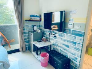 a room with a desk in a room with blue tiles at Yun He Homestay in Huwei