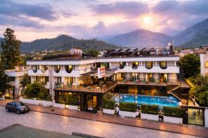 a hotel with a pool and mountains in the background at Britannia Hotel in Kemer