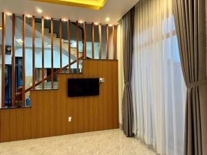 a living room with a staircase and a television at Arden Villa Quy Nhơn in Quy Nhon
