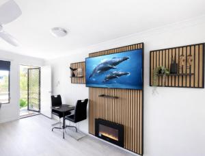 a living room with a whale painting on the wall at Waters Edge in Urangan